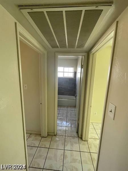 hallway featuring visible vents and light tile patterned floors