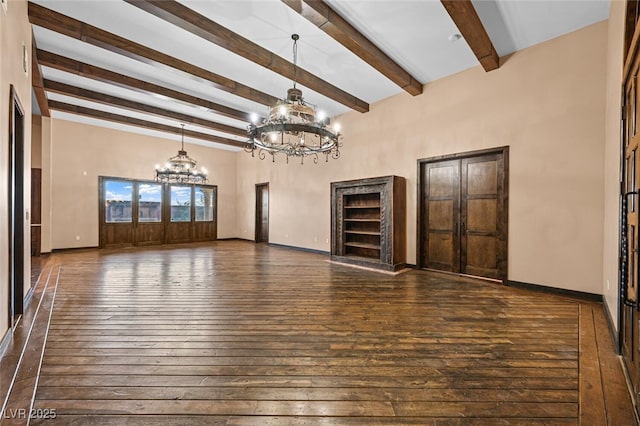 interior space with baseboards, a chandelier, and dark wood finished floors