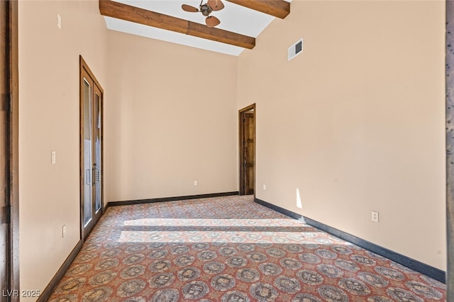 unfurnished room featuring beam ceiling, visible vents, a ceiling fan, high vaulted ceiling, and baseboards