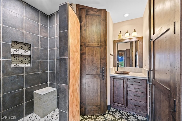 bathroom featuring tiled shower and vanity