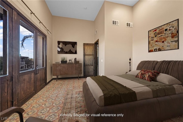 bedroom with visible vents and a towering ceiling