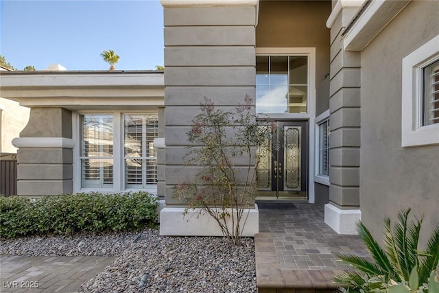 entrance to property featuring stucco siding