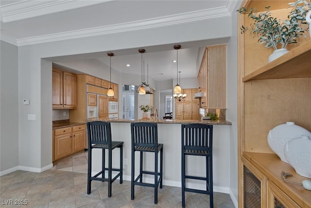 kitchen with dark stone counters, a breakfast bar area, decorative light fixtures, a peninsula, and light brown cabinetry