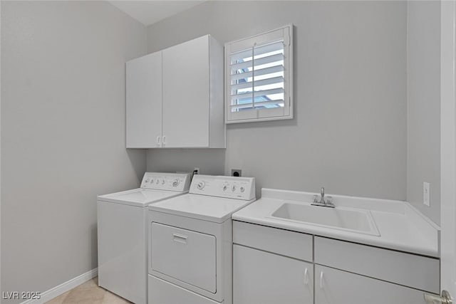 laundry room featuring cabinet space, baseboards, separate washer and dryer, and a sink