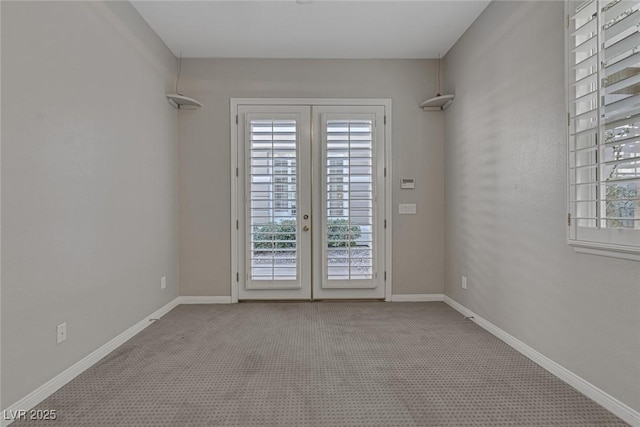 empty room featuring french doors, light carpet, and baseboards