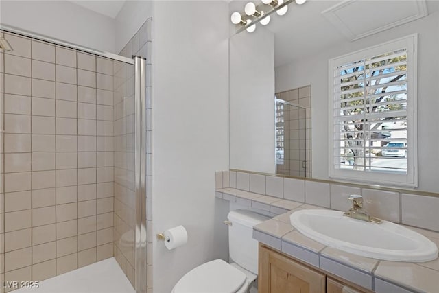 bathroom featuring toilet, a stall shower, and vanity