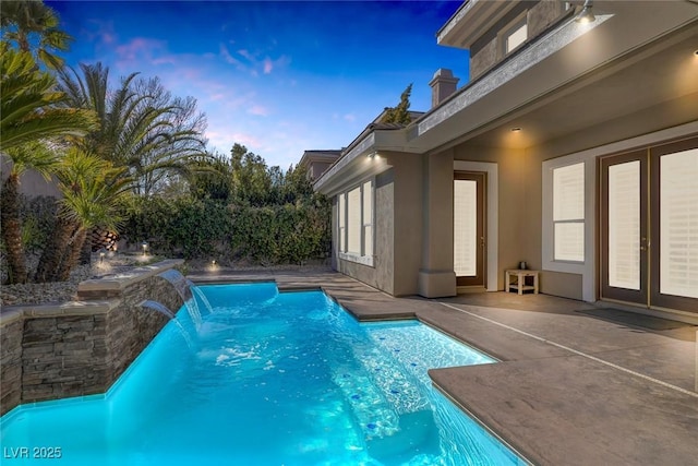 pool at dusk with a patio