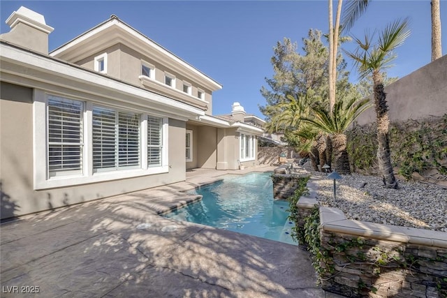 outdoor pool featuring fence and a patio