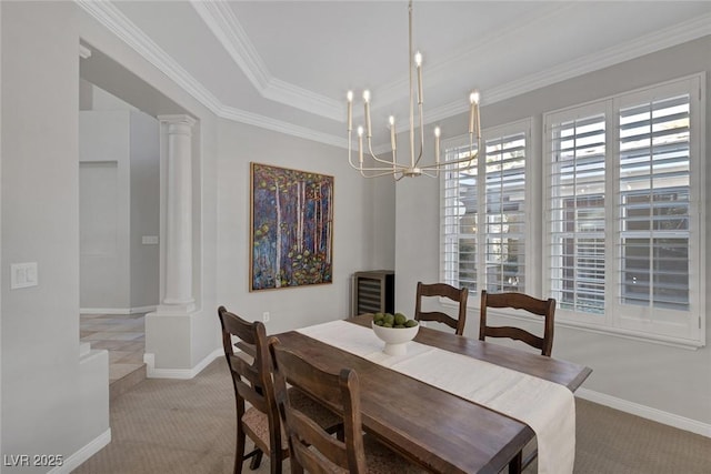 dining room featuring light carpet, decorative columns, ornamental molding, and a notable chandelier