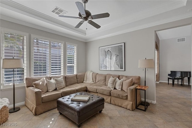 living area featuring baseboards, visible vents, a tray ceiling, and ornamental molding