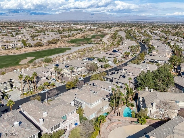 drone / aerial view with a mountain view, golf course view, and a residential view