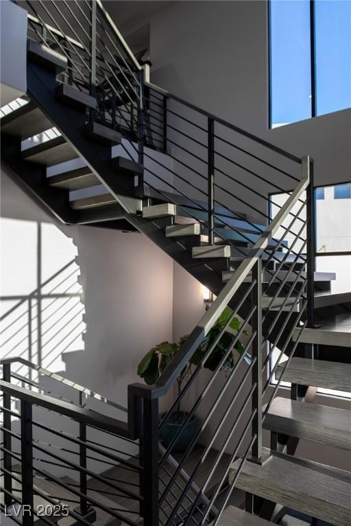 staircase featuring plenty of natural light and a high ceiling