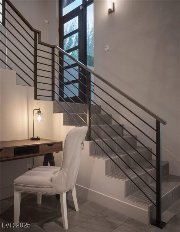 stairway with baseboards and built in study area