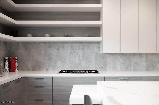 kitchen featuring white cabinetry, stainless steel gas cooktop, backsplash, and modern cabinets