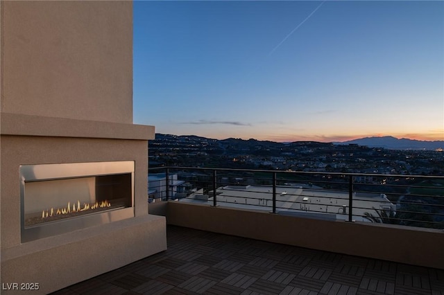 balcony at dusk with a warm lit fireplace and a mountain view