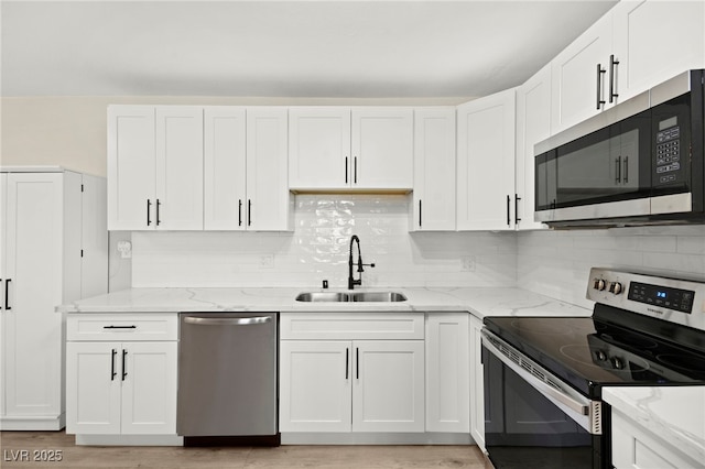 kitchen featuring stainless steel appliances, white cabinets, and a sink