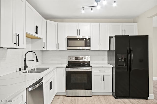 kitchen with white cabinets, stainless steel appliances, and a sink