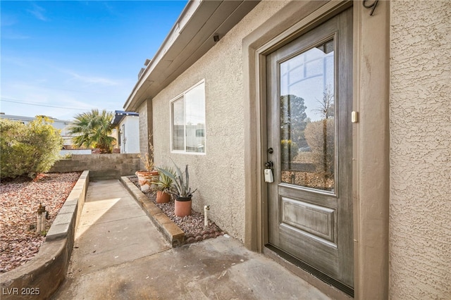 doorway to property featuring a patio, fence, and stucco siding