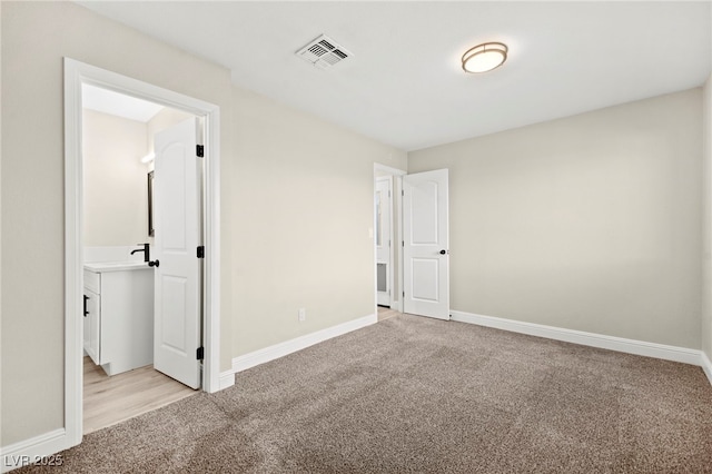 unfurnished bedroom with light carpet, visible vents, and baseboards