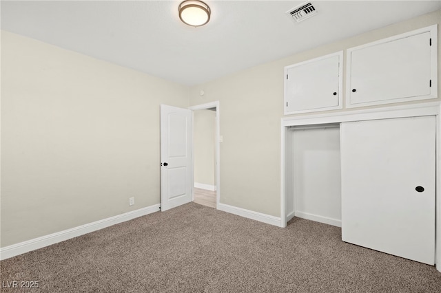 unfurnished bedroom featuring a closet, light colored carpet, visible vents, and baseboards