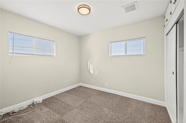 unfurnished bedroom with carpet floors, baseboards, visible vents, and a closet