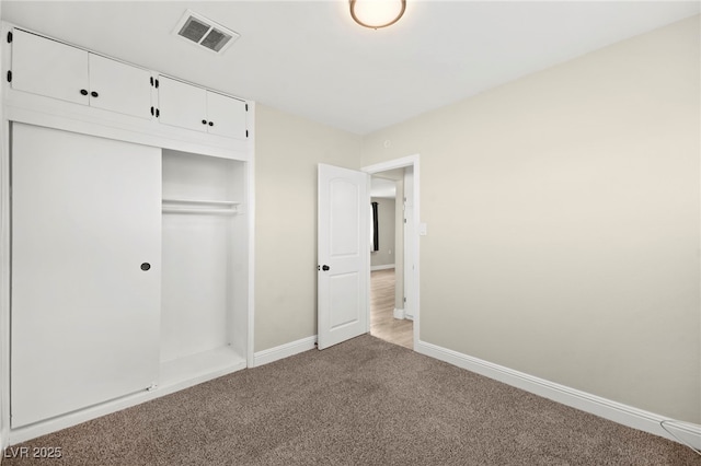 unfurnished bedroom featuring light carpet, baseboards, visible vents, and a closet