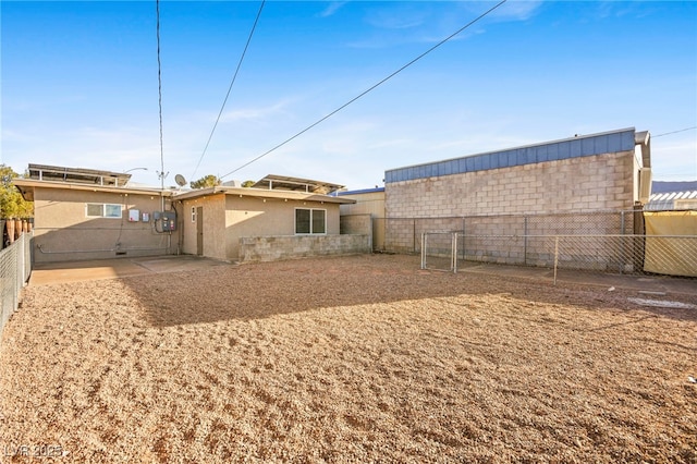 rear view of house featuring a fenced backyard, a patio, and stucco siding