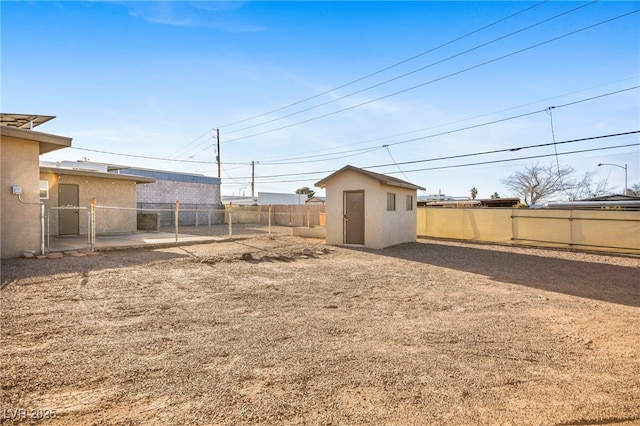 view of yard featuring a fenced backyard, an outdoor structure, and a storage shed