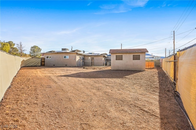 back of property with a fenced backyard and stucco siding