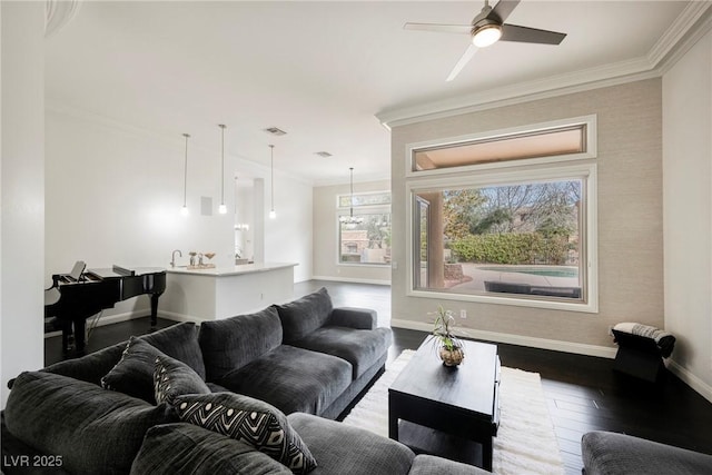 living area featuring dark wood-style flooring, crown molding, visible vents, ceiling fan, and baseboards