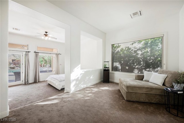 carpeted bedroom with access to exterior, visible vents, baseboards, and a ceiling fan