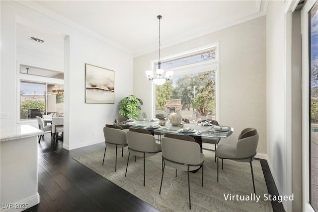 dining space with dark wood-type flooring, visible vents, a chandelier, and crown molding