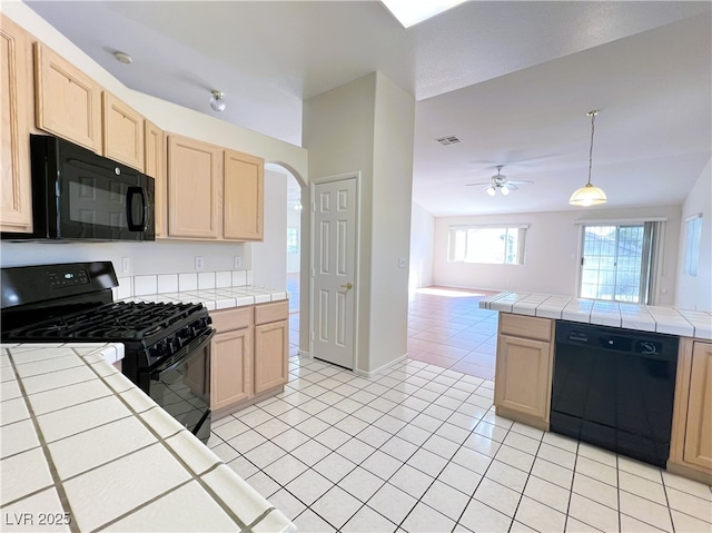 kitchen with tile countertops, black appliances, and light brown cabinetry