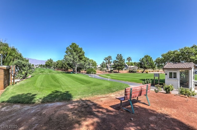 view of home's community with golf course view and a yard