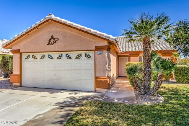 view of front facade featuring an attached garage, driveway, a tile roof, and stucco siding