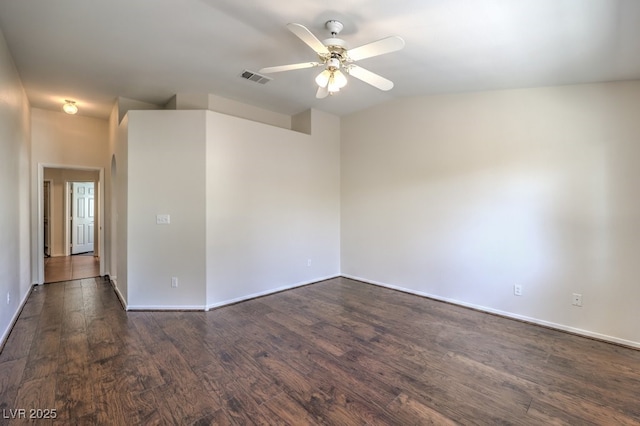 spare room featuring baseboards, ceiling fan, visible vents, and dark wood-type flooring