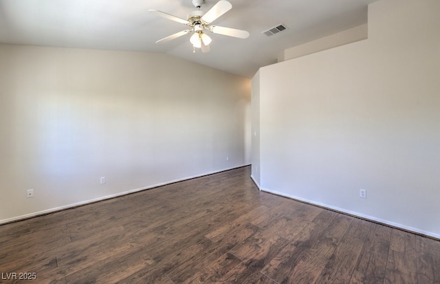 spare room featuring ceiling fan, visible vents, vaulted ceiling, and dark wood-type flooring