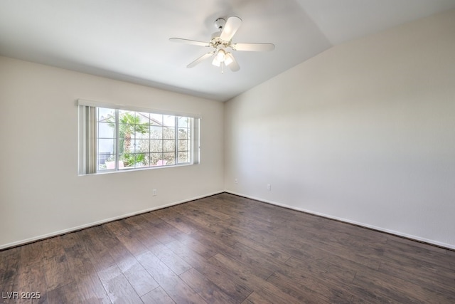 spare room featuring vaulted ceiling, ceiling fan, dark wood finished floors, and baseboards