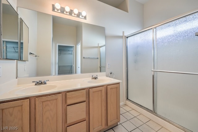 full bath with tile patterned flooring, a shower stall, a walk in closet, and a sink