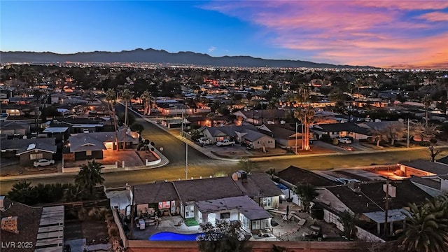 aerial view at dusk featuring a residential view and a mountain view