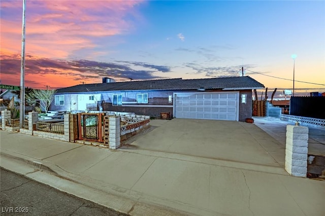 ranch-style house featuring a garage, fence, and driveway