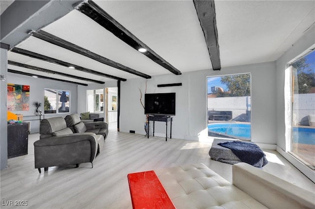 living room featuring beamed ceiling and light wood-style flooring