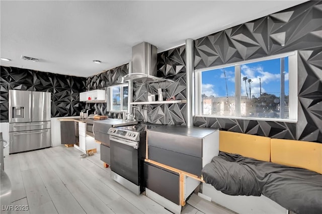 kitchen with range hood, dark countertops, visible vents, light wood-style flooring, and appliances with stainless steel finishes