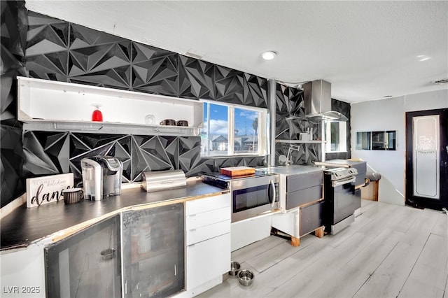 kitchen featuring open shelves, appliances with stainless steel finishes, white cabinetry, modern cabinets, and wall chimney exhaust hood