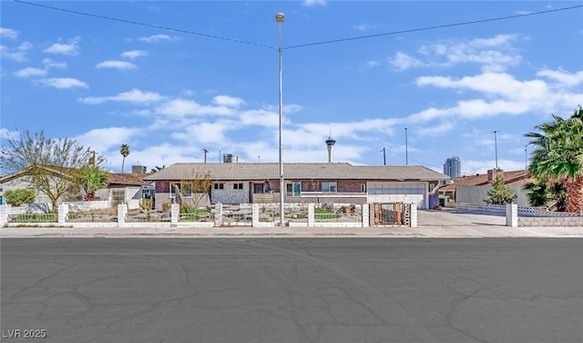 single story home featuring concrete driveway and fence