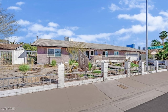 single story home featuring driveway, a fenced front yard, a tile roof, and stucco siding