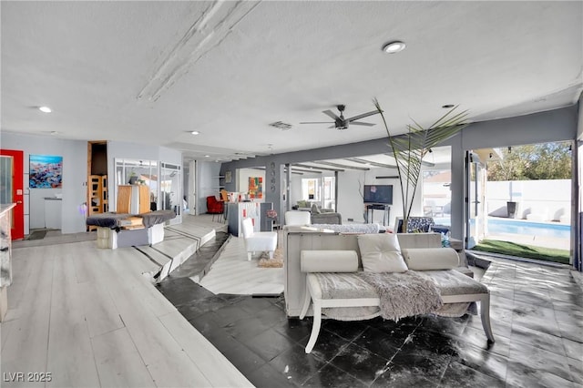 living area with ceiling fan, dark wood-style floors, visible vents, and recessed lighting