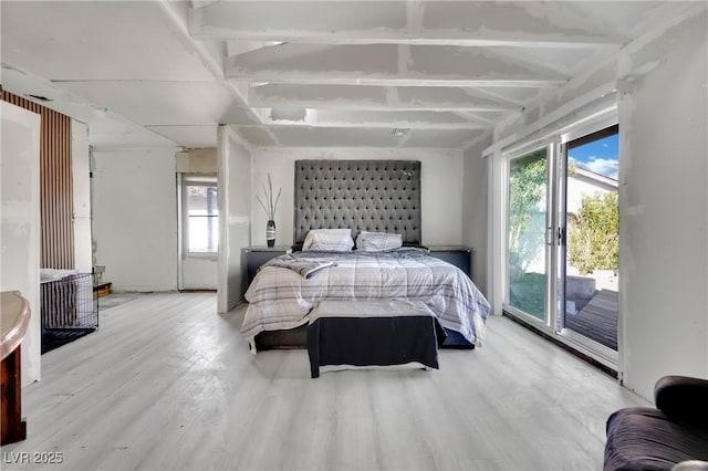 bedroom with access to outside, multiple windows, and light wood-style floors