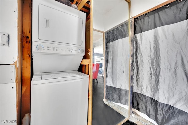 clothes washing area featuring laundry area and stacked washer / dryer