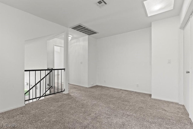 carpeted spare room featuring visible vents and baseboards